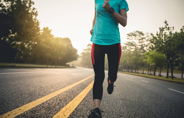 Young fitness woman running on city road at sunrise - Φωτογραφία, εικόνα