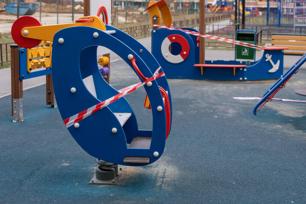 Um parque infantil com um helicóptero de madeira embrulhado em fita adesiva, ficar em casa. Sanitização de um complexo de esportes de rua, prevenção de infecção do coronavírus pandemia covid-19
 - Foto, Imagem