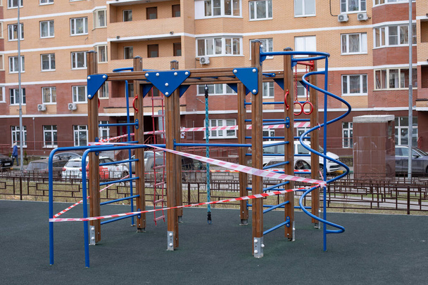 Playground wrapped in striped red white tape, stay home. Quarantine area for sports, prevention of infection with the covid-19 coronavirus influenza virus - Photo, Image
