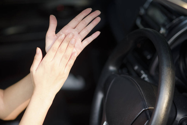 woman is applying hands sanitizer on her hands in car - Foto, Bild