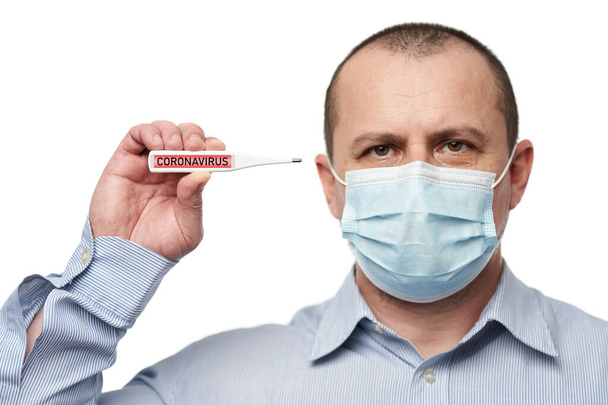 Man with face mask showing a thermometer with coronavirus alert - Foto, immagini