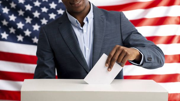 Seçmen oy pusulasını çekiyor. Arka planda ABD bayrağı - Fotoğraf, Görsel