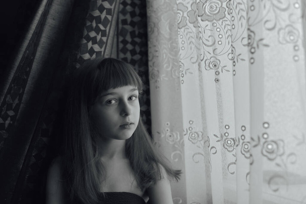 Schoolgirl home. A schoolgirl stays home. Portrait of a girl of 9 years old. The child sit next to the window. Children of the Z-generation. Portrait of a little girl. teenager, coronavirus, covid-19 - Photo, Image
