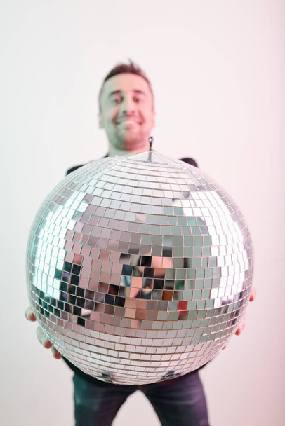 Opgewonden jongeman met grote glimmende discobal - Foto, afbeelding