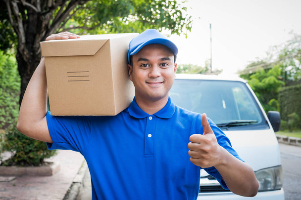 Голубой доставщик с картонной коробкой для посылок
. - Фото, изображение