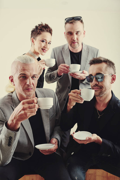 Divertenti membri della band musicale che bevono tè dopo essersi esibiti al concerto
 - Foto, immagini