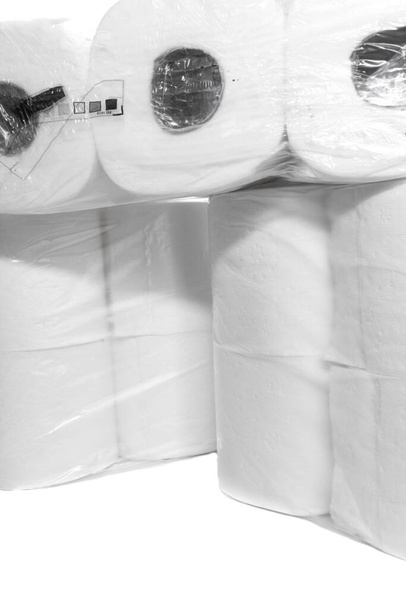 Verpakkingen van wc-papier gestapeld op elkaar op een witte achtergrond. - Foto, afbeelding
