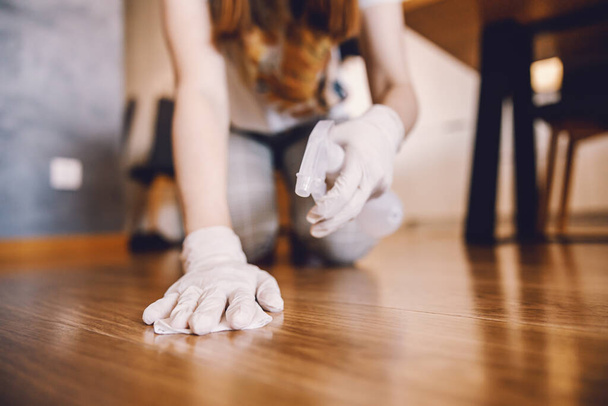 Kadın antibakteriyel mendille yerleri temizliyor ve ev yüzeyindeki virüsleri temizliyor. Corona virüsü önleyici tedbirler. - Fotoğraf, Görsel