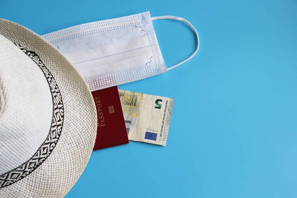 Coronavirus covid-19 et concept de voyage. Vacances d'été : passeport, argent et masque respiratoire sur fond bleu. Couché plat ou vue du dessus
. - Photo, image