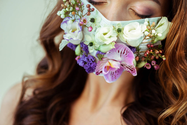 vista cortada de mulher com olhos fechados em máscara floral isolada em cinza
 - Foto, Imagem