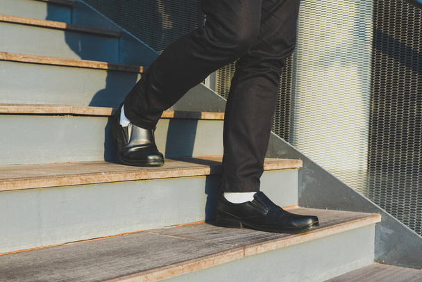 Επιχειρηματίες με τα πόδια μέχρι τις σκάλες Με φόντο την μητρόπολη Οικονομικών, εφαρμογή - Φωτογραφία, εικόνα
