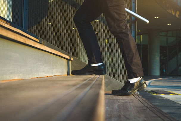 Empresários subindo as escadas com um pano de fundo para a metrópole Finanças, aplicação
 - Foto, Imagem