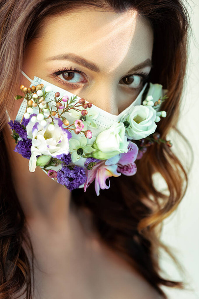 attractive woman in floral face mask looking at camera isolated on white - Foto, afbeelding