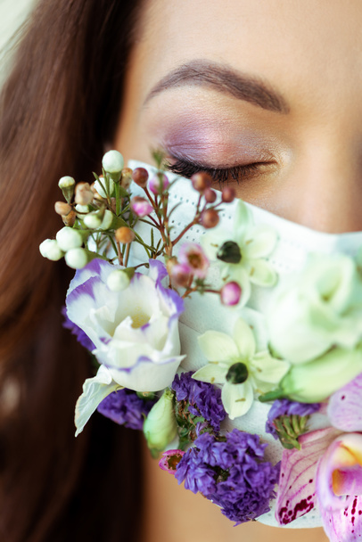 cropped view of woman with closed eyes in floral face mask  - Foto, afbeelding