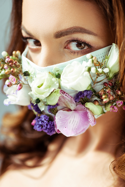 επιλεκτική εστίαση της νεαρής γυναίκας με μάσκα προσώπου με λουλούδια - Φωτογραφία, εικόνα