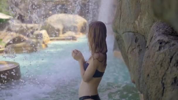温泉、滝、温水プール付きの熱帯リゾートの若い女性。スローモーションショット - 映像、動画