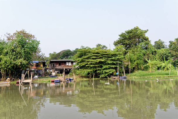 Traditional Thai house by the water on the banks of the Chao Phraya River in Ayutthaya, Thailand - 21 January 2020 - Photo, Image