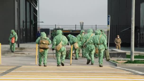 Работники защитных костюмов для защиты от биовирусов ходят, чтобы дезинфицировать коронавирус COVID-19. Антибактериальные санитарные меры по карантину. UltraHD 4K
 - Кадры, видео