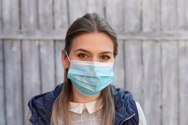 Young caucasian woman with surgical mask outdoor - covid-19 quarantin - Фото, зображення
