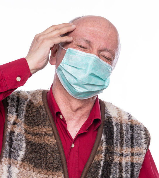 Gesundheitswesen, Schmerz, Stress und Alterskonzept. Kranker alter Mann. Senior Mann in Maske leidet unter Kopfschmerzen vor weißem Hintergrund - Foto, Bild