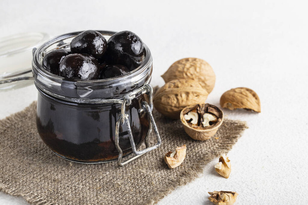 walnut jam in a jar on a white background - Foto, Bild