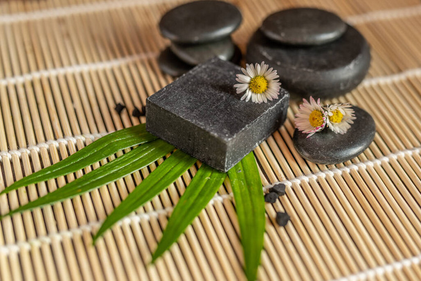 charbon de bois carbone noir savon bar sur un bois brut bambou fond lave pierre spa soins de la peau concept d'hygiène
 - Photo, image