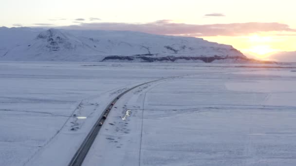 AERIAL: Magas hó feletti fehér táj közúti autókkal Izlandon Tél, naplemente, sarkvidék - Felvétel, videó