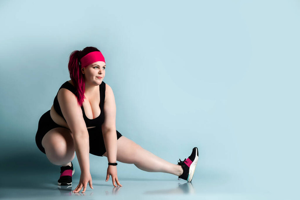 Fitness spring diet weight loss concept. Lucky plus-size girl overweight woman dieting working out doing stretching exercises - 写真・画像
