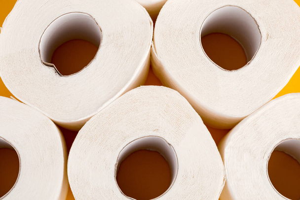 Toiletpapier rollen op een gele achtergrond - Foto, afbeelding