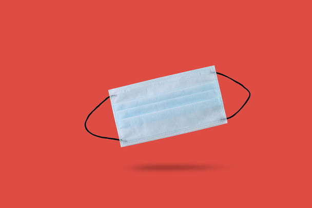 Medical mask, Medical protective masks on red background. Prevent coronavirus. Protection against virus, coronavirus. flat lay top view with copy space. Healthcare and medical concept. - Photo, Image
