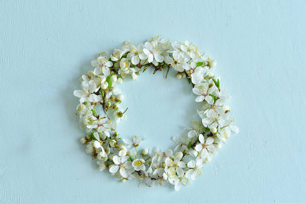 フラワーアレンジメント。桜の花の富。フレームの形で薄い青の背景に白い花。イースター、春、夏、バレンタインデーのコンセプト。フラットレイアウト、トップビュー、コピースペース。フラワーカード - 写真・画像