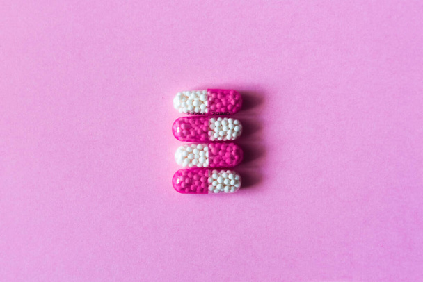 Heap of colorfull pills, tablets, capsules on pink background. Drug prescription for treatment medication health care concept wth copy space - 写真・画像