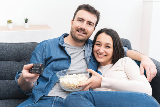 Happy couple watching television at home spending time - Foto, Imagem