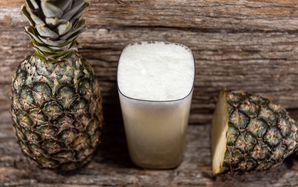 Pineapple juice and fruits (Ananas comosus). Fruit-symbol of tropical and subtropical regions, widely accepted throughout the world, both natural and industrialized - Фото, зображення