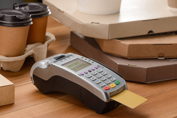 POS terminal with inserted credit card, coffee and pizza - Valokuva, kuva
