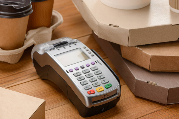 Close-up on a payment terminal between pizza boxes and coffee cups - Fotoğraf, Görsel