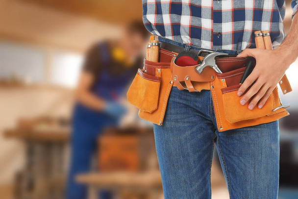 Carpenter with tool belt in workshop, closeup - Фото, зображення