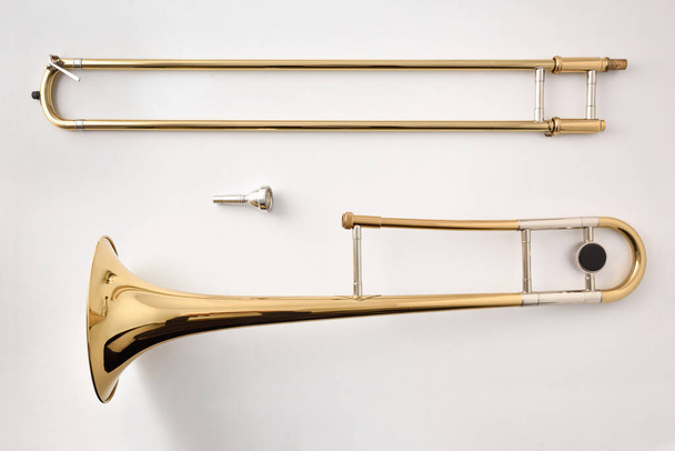 Trombone disassembled on white table. Top view. Horizontal composition. - Фото, изображение