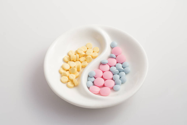 plato pequeño con varias píldoras narcóticas sobre un fondo blanco
 - Foto, imagen