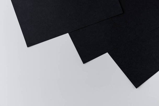 Patroon van zwart papier gelegd in de vorm van stralen de een na de ander op een witte achtergrond - Foto, afbeelding