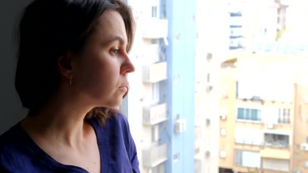 Frau blickt aus dem Fenster in die Ferne - Filmmaterial, Video