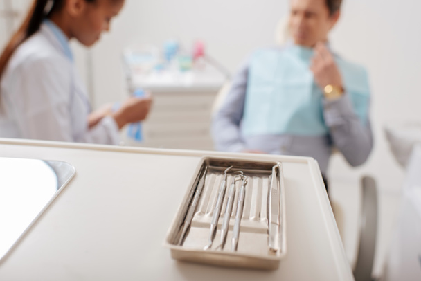 selective focus of dental instruments near african american dentist and patient  - Фото, зображення