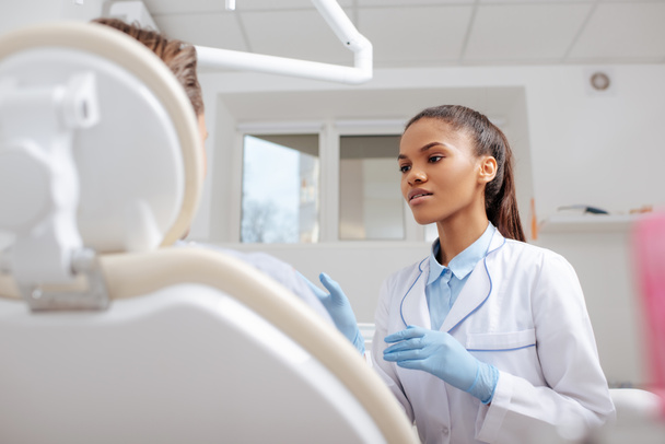 selective focus of african american dentist looking at patient  - Photo, Image