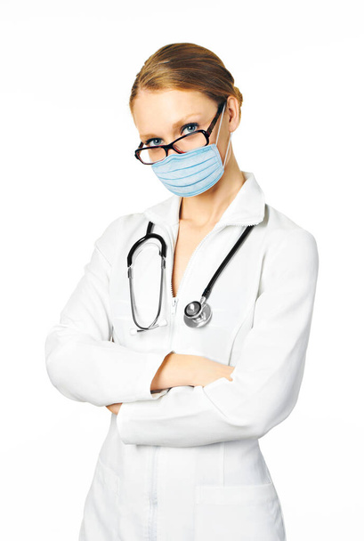 Vrouwelijke arts met stethoscoop in een beschermmasker, ter preventie van covid-19 virus - Foto, afbeelding