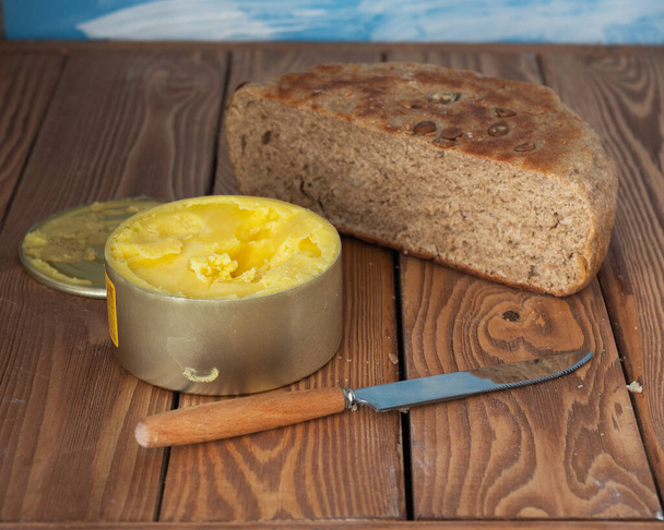 Pół domowej roboty świeżo upieczony chleb pełnoziarnisty i roztopione masło w puszce - Zdjęcie, obraz