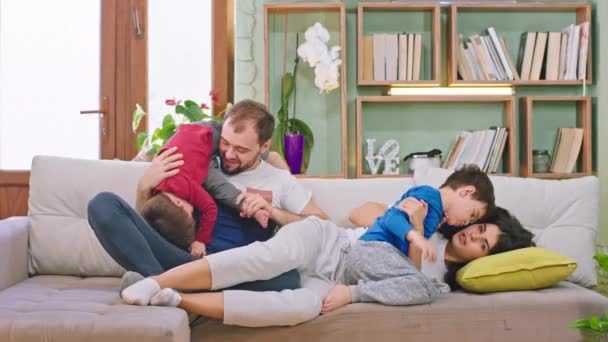 Charismatische Eltern und ihre Kinder verbringen eine lustige Zeit miteinander, spielen und plaudern zusammen und genießen den Moment mit der Familie, während sie zu Hause bleiben - Filmmaterial, Video