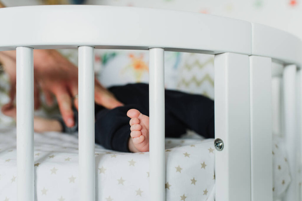 Крупный план ноги новорожденного в кроватке
. - Фото, изображение