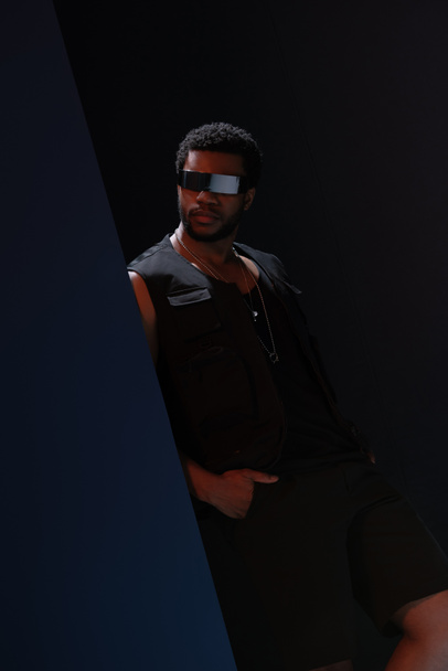 lunettes de soleil futuristes modèle masculin afro-américain en posant sur bleu foncé
 - Photo, image