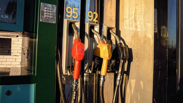 Close-up of three fuel nozzles for gasoline, refueling. Sunset light. Car ride. Travels. - Photo, Image
