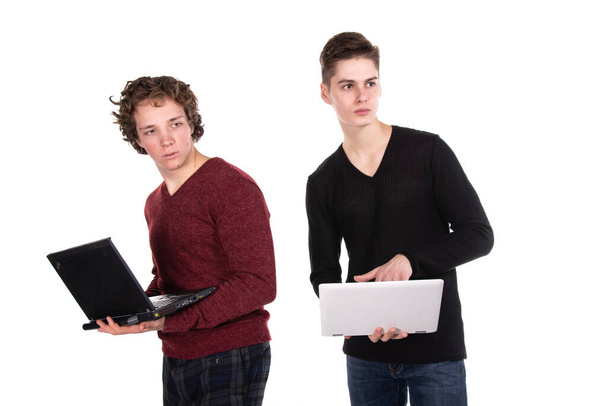 Two attractive students. Laptop. White background. - Фото, изображение